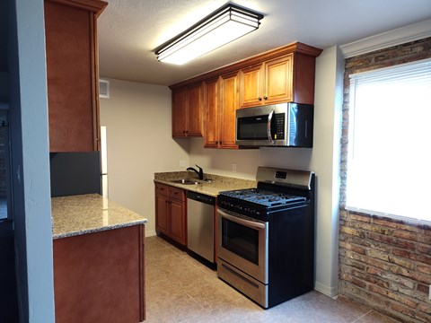 A kitchen with black appliances and wooden cabinets.